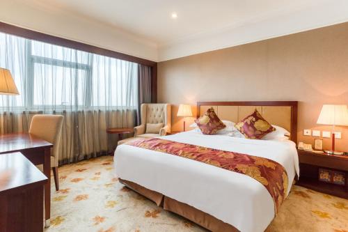 长春长春国盛维景酒店的酒店客房设有一张大床和一张书桌。