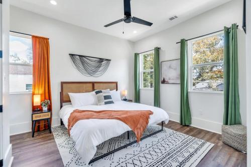 新奥尔良Modern Mid-city Maison的一间卧室设有一张床和两个窗户。