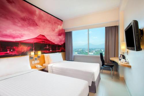 梭罗favehotel Manahan - Solo的一间酒店客房,设有两张床和电视