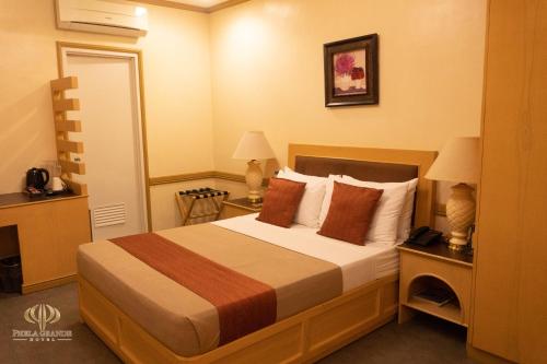 桑托斯将军城PHELA GRANDE HOTEL的酒店客房,配有一张床和两盏灯