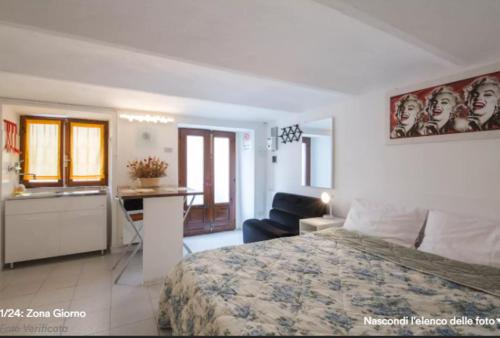 阿斯蒂Location Turistic Monolocale nel Parco del Santuario CIR 00033的一间带一张床和一张书桌的卧室和一间厨房