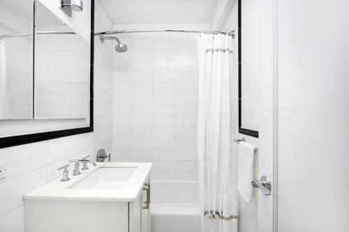 纽约Cozy Studio Apartment的白色的浴室设有水槽和淋浴。