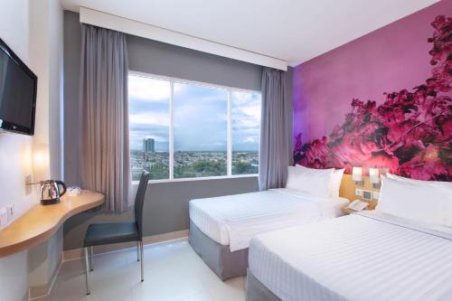 梭罗梭罗巴鲁最爱酒店的酒店客房设有两张床、一张书桌和一个窗户。