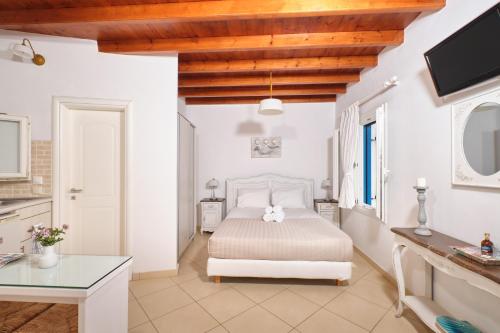 卡塔波拉Amorgion Hotel的白色卧室配有床和桌子