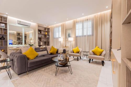 利雅德Amber Al Qairwan的带沙发和黄色枕头的客厅