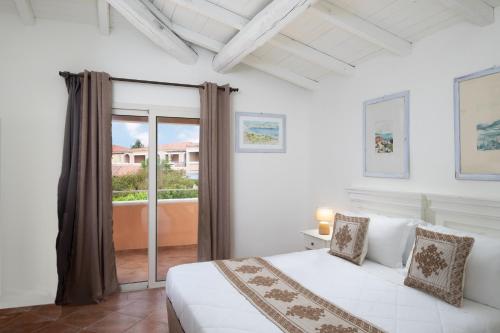 阿兰奇湾城VOI Colonna Village的一间白色卧室,配有床和阳台