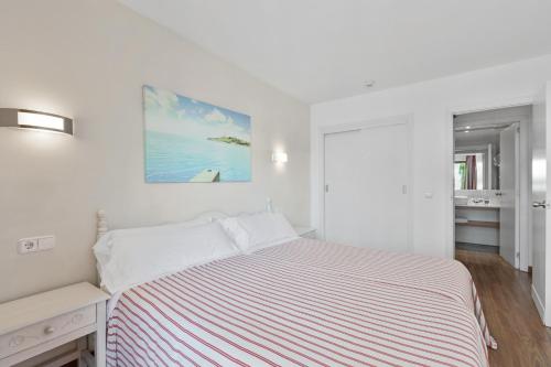 帕尔马海滩Apartamentos Pabisa Orlando的白色卧室配有一张床,墙上挂着一幅画