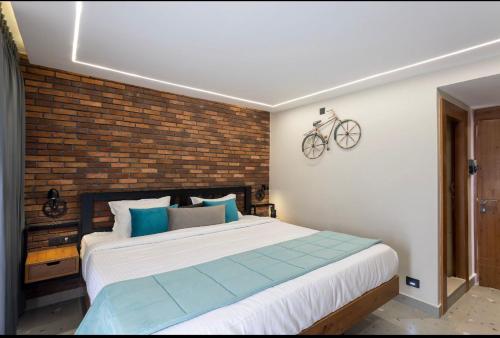 乌提Hotel Maneck Manor的卧室配有一张大床,墙上挂有自行车