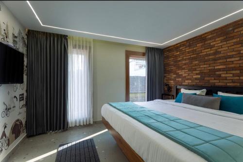 乌提Hotel Maneck Manor的一间卧室设有一张大床和砖墙