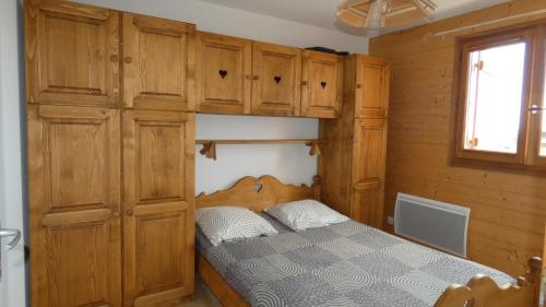 托隆伊特宜姆比乐2公寓酒店的一间卧室配有一张床和木制橱柜