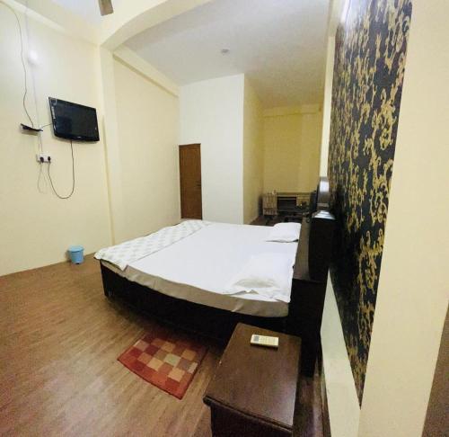 瓦拉纳西RN Residency的一间小卧室,配有一张床和一张桌子