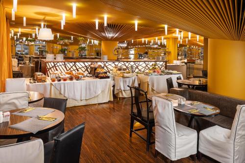 布拉格珀拉酒店的用餐室配有桌子和白色的椅子以及桌子。