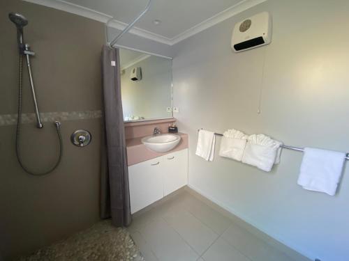 陶波Lakeside Taupo Motel的浴室配有盥洗盆、淋浴和毛巾