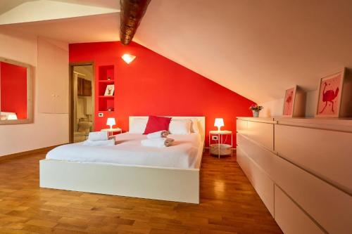米兰Moscova Charme Apartment的卧室设有红色墙壁和白色的床