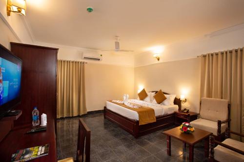 特里凡得琅Hotel Keerthi的一间酒店客房,配有一张床和一台电视
