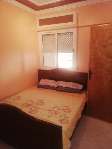 Appartement Boekidan/Al houceima的一间小卧室,配有一张带窗户的床