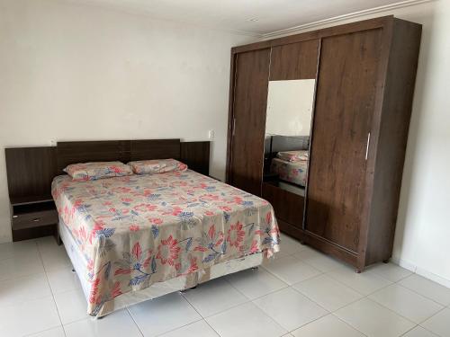 福塔莱萨Guilherme Hostel的一间卧室配有一张床和一个大型木制橱柜