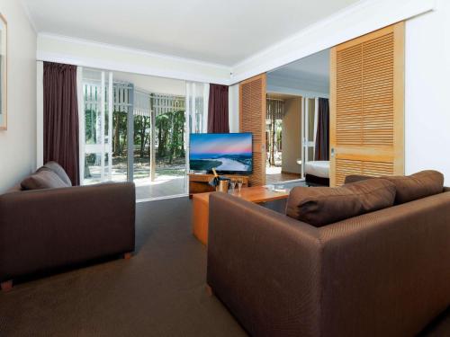 双水域Novotel Sunshine Coast Resort的客厅配有2张沙发和1台平面电视