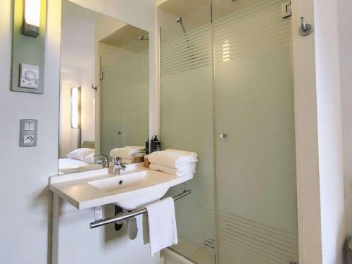 土伦Ibis Budget Toulon Centre的一间带水槽和玻璃淋浴的浴室