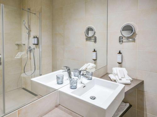 日内瓦Mercure Geneva Airport的白色的浴室设有水槽和淋浴。