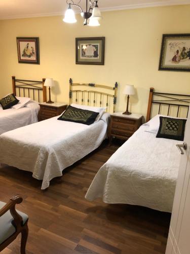 曼西利亚德拉斯穆拉斯MENCIA的一间卧室设有两张床和两张带台灯的桌子。