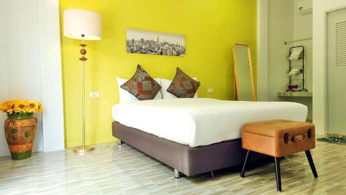Ban Khuan Raeบ้านเพิงโฮมสเตย์的卧室配有一张白色大床和黄色墙壁