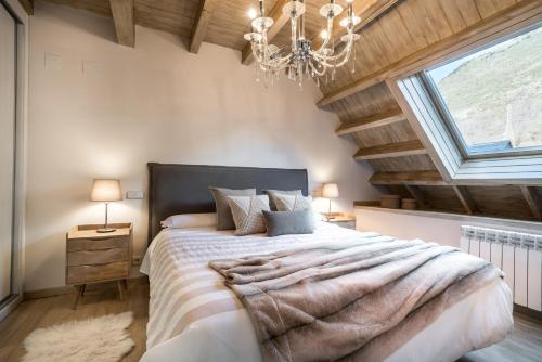 贝特伦Casa Baqueira的一间卧室配有一张大床和一个吊灯。