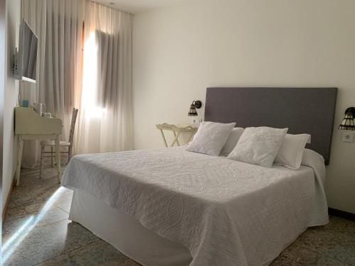 卡拉瓦卡·德·拉·克鲁斯Círculo Artístico 1911 Hotel Boutique的白色卧室配有一张带白色床单的大床