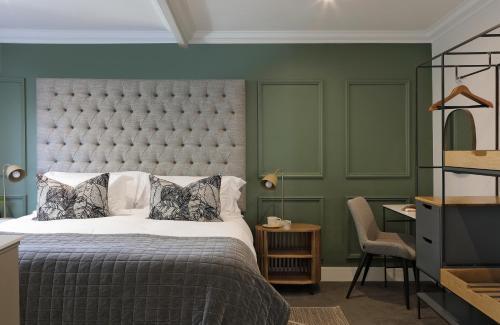 斯泰伦博斯Twice Central Guest House的一间卧室设有一张大床和绿色的墙壁