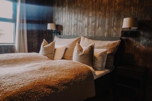 哈山哈弗耶尔皮勒斯托瓦酒店的卧室配有带枕头的床铺和窗户。