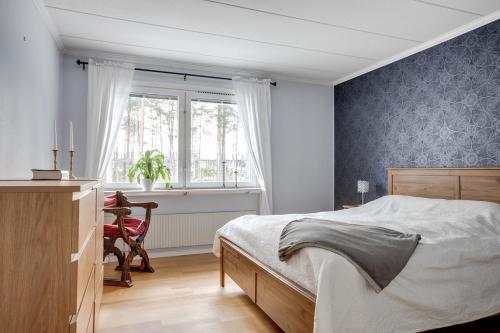 耶夫勒Vikingavägen 75的卧室配有床、椅子和窗户。