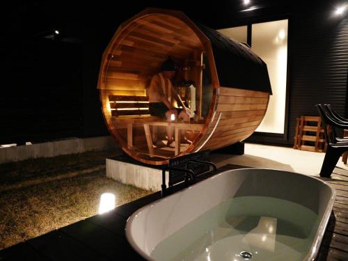 屋久岛SAKURA YAKUSHIMA的带浴缸的浴室和圆镜子