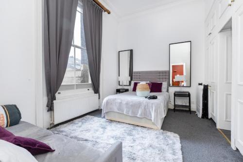 伦敦Harrods Flats的一间白色卧室,配有两张床和窗户
