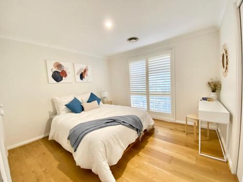 悉尼Cosy 3BR House, 7 mins drive to Macquarie Centre, 5 stars on AirB&B的白色的卧室设有床和窗户