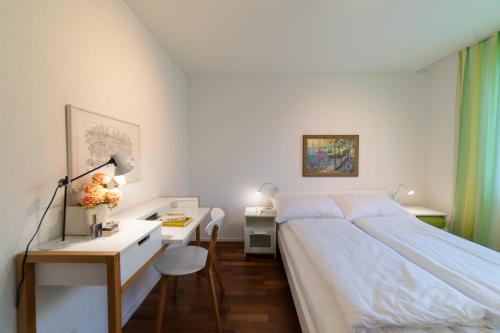 维尔德豪斯Rietgarten的一间卧室配有一张床和一张带台灯的书桌