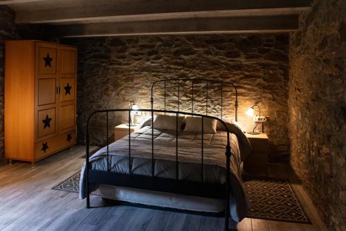 蒙塞尼Masia Casa Nova de n'Illa的一间石墙内带金属床的卧室
