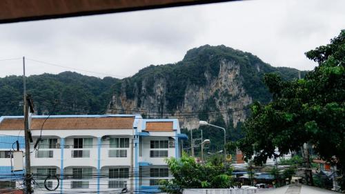 奥南海滩Aonang Knockout Hostel的一座白楼,背景是一座山