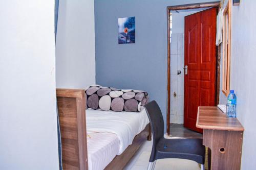 KaratinaDad's Place的小房间设有床、书桌和红色门