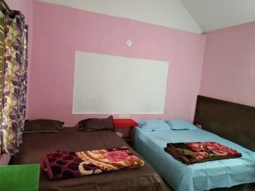 蒙纳Munnar green portico cottage的配有粉红色墙壁的客房内的两张床