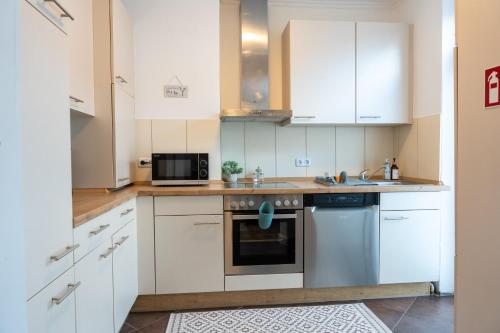 不莱梅Volante Apartment Bremen-Findorff的厨房配有白色橱柜和微波炉