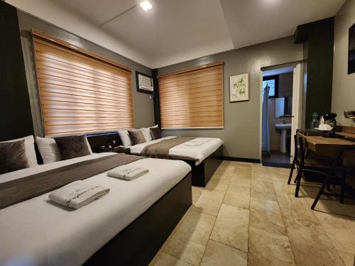大雅台Grayhouse Inn Tagaytay的酒店客房配有两张床和一张书桌