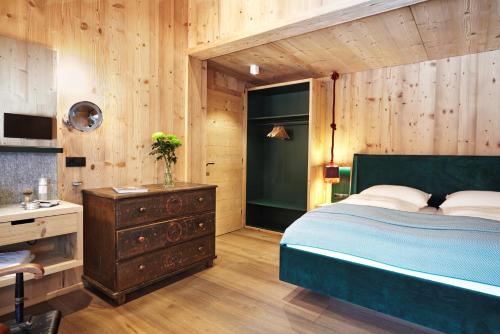 KleinbodenAlpenLuxus' MOUNTAIN SUITE in the SportLodge with natural pool, whirlpool & sauna的一间卧室设有一张床和木墙