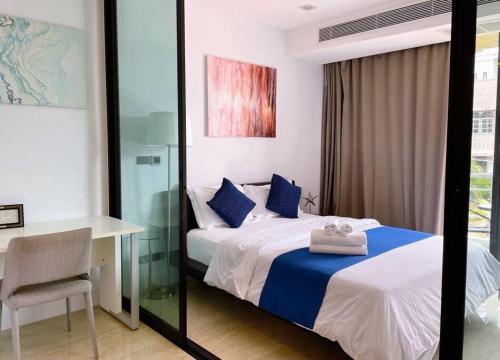 卡塔海滩4 beds 5baths Pool Villa at Kata beach的一间卧室配有一张床、一张桌子和一张书桌
