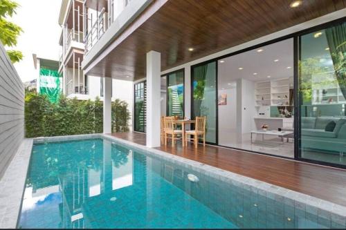卡塔海滩4 beds 5baths Pool Villa at Kata beach的房屋前有游泳池的房子