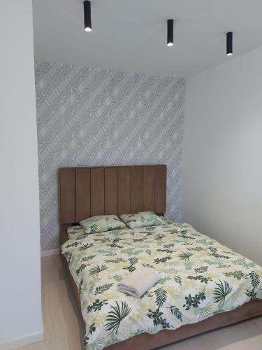 阿拉木图ЖК Palladium/41的一间卧室配有一张带木制床头板的床