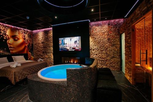 奈梅亨City Spa Nijmegen的一间设有按摩浴缸和电视的客房