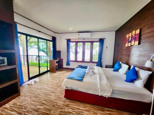 拉迈苏梅岛沙罗查别墅三棵树度假酒店的一间卧室配有一张带蓝色枕头的大床