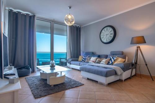 滨海保尔Apartment 7 on Paul do Mar Beach的客厅配有沙发和墙上的时钟