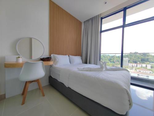 哥打京那巴鲁Cityview Studio Apartment at Kota Kinabalu City Centre的一间卧室配有一张床、镜子和椅子