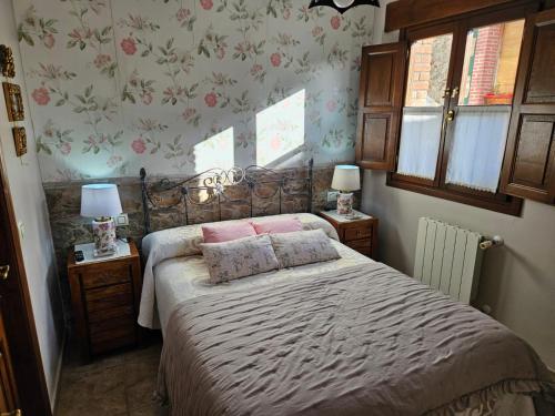 利亚内斯El Rincón del Oteru的一间卧室配有带粉红色枕头的床。